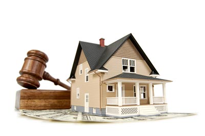 A graphic with a house in front of a gavel